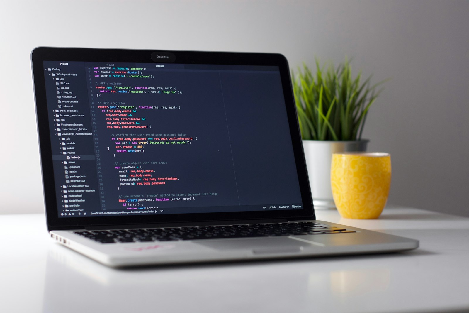 Developer writing mobile app code on a laptop