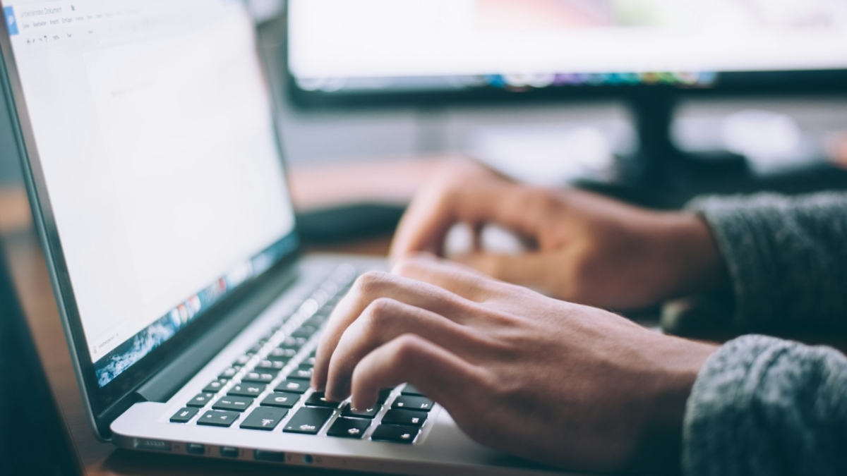 Typing a professional email on a laptop